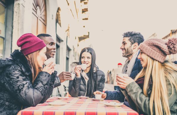 گروه چند قومیتی از دوستان نشسته در یک قهوه و نوشیدن - دانش آموزان شاد در یک قهوه خانه برای استراحت ملاقات می کنند