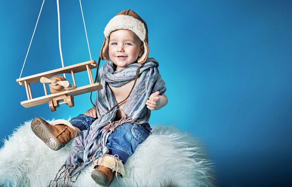 پسر بچه ناز با یک هواپیمای اسباب بازی قدیمی