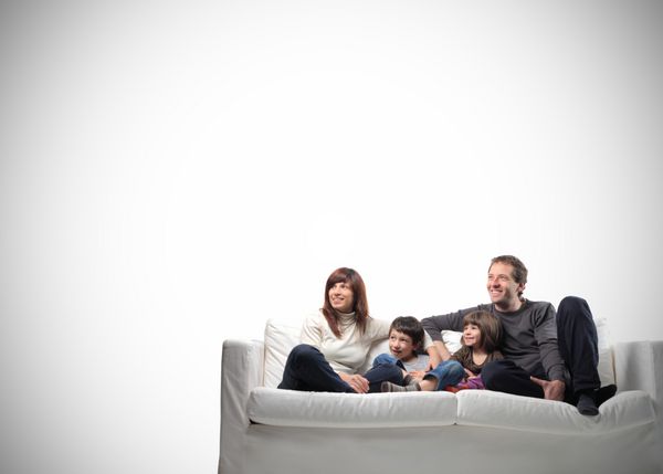 خانواده شاد نشسته روی یک مبل با فضای کپی