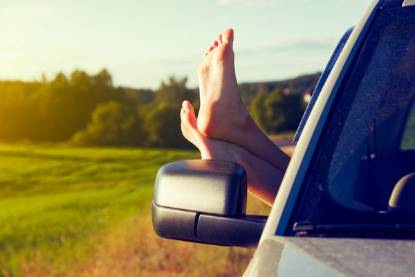 پاهای زن از شیشه ماشین بیرون است مفهوم آزادی یا سفر