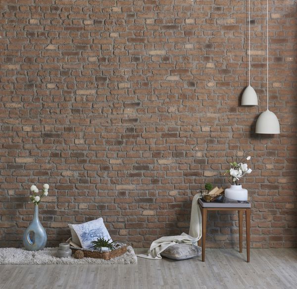 کاغذ دیواری آجری طبیعی با صندلی حصیری مدرن و گلدان گل