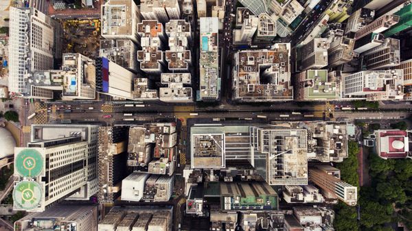 عکس هوایی با نمای بالا از پهپاد پرنده یک شهر جهانی هنگ کنگ با ساختمان های توسعه حمل و نقل زیرساخت انرژی انرژی مراکز مالی و تجاری در شهر توسعه یافته چین