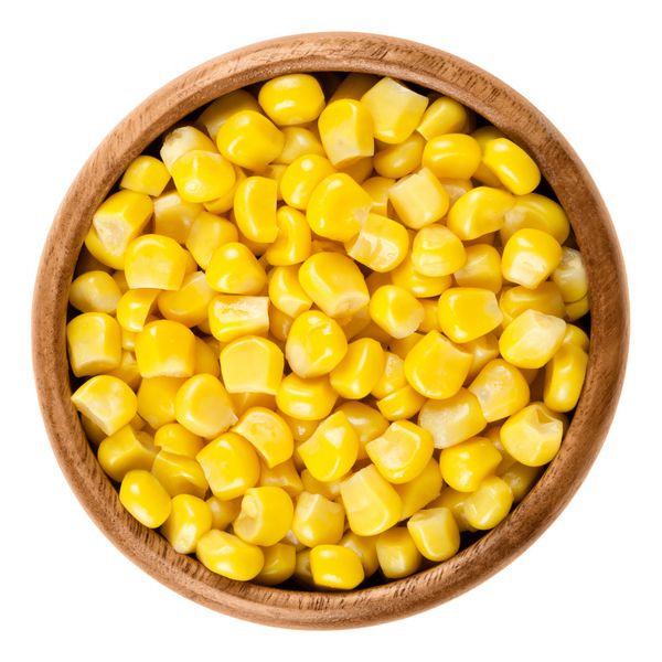 دانه های ذرت شیرین در کاسه چوبی روی سفید کنسرو ذرت سبزی زرد Zea mays که شکر یا ذرت قطبی نیز نامیده می شود غذای اصلی گیاهی است عکس ماکرو جدا شده از نزدیک از بالا
