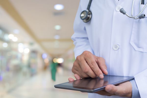 دکتری که روی رایانه لوحی دیجیتال در بیمارستان کار می کند سیستم مدارک الکترونیکی پزشکی سیستم پرونده الکترونیک سلامت EMRs مفهوم EHRs