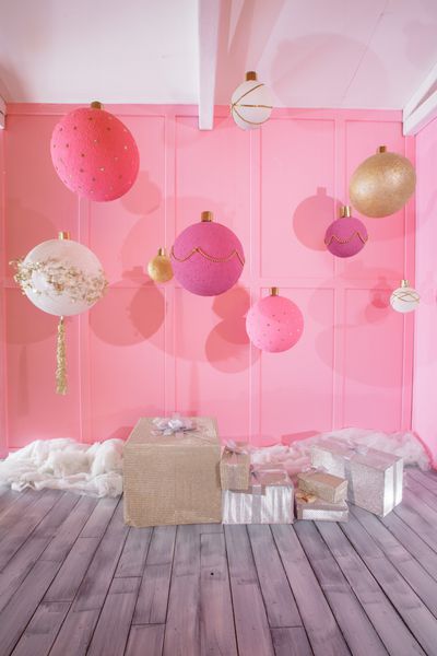توپ های کریسمس بزرگ در پس زمینه صورتی در اتاق کودکان