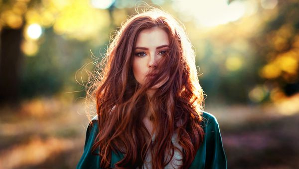 پرتره نزدیک از یک دختر زیبا با موهای قرمز با لباس سبز قرون وسطایی روی خورشید درخشان داستان پری در مورد زن دلیر مدلی شگفت انگیز که به دوربین نگاه می کند کار هنری گرم