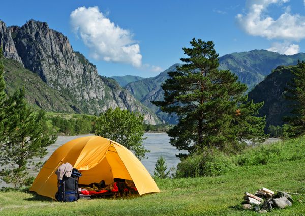 چادر کمپینگ در نزدیکی رودخانه کوه در تابستان