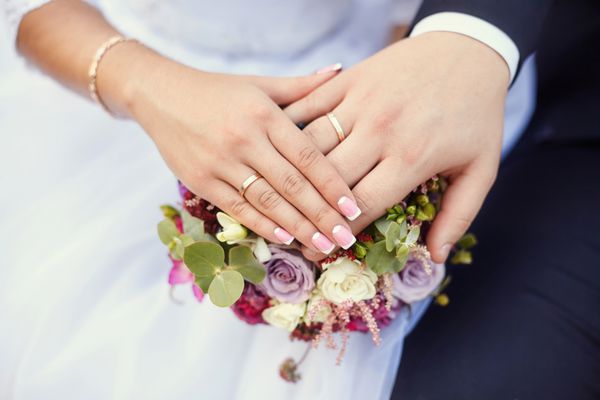 دستان عروس و داماد با حلقه روی دسته گل عروسی مفهوم ازدواج