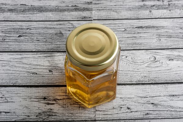 عسل در یک شیشه سنگ تراشی روی زمینه چوبی
