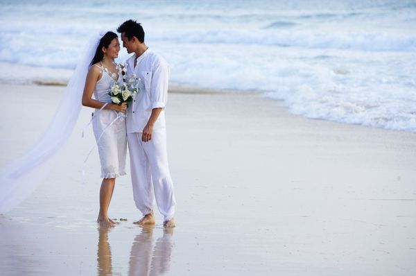 عروس و داماد در ساحل رو در رو ایستاده اند