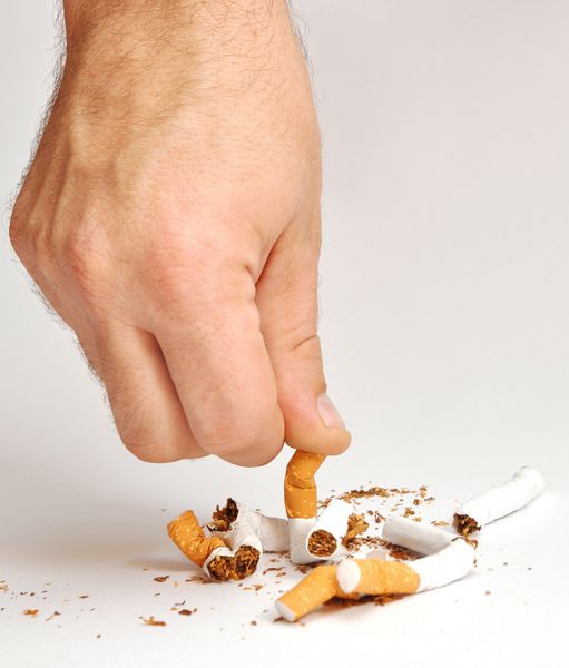 مرد دستی آخرین سیگار را خرد می کند سیگار نکش