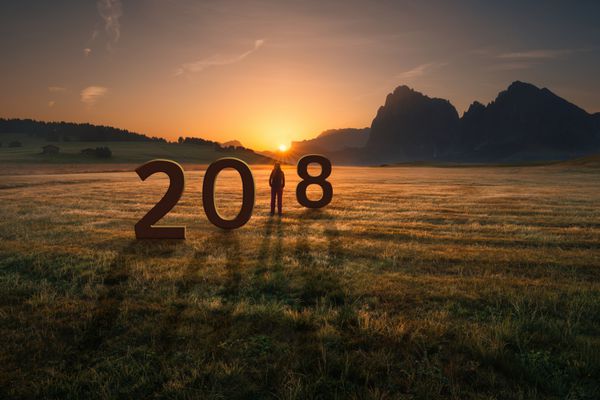 زن جوان ایستاده و تماشای طلوع خورشید عدم اطمینان برای سال جدید 2018 مفهوم گذر زمان و آینده