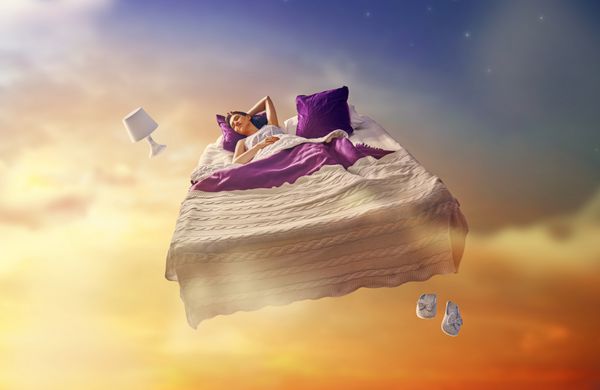 رویاهای زن دختر زیبا در تختش در میان آسمان ستاره پرواز می کند