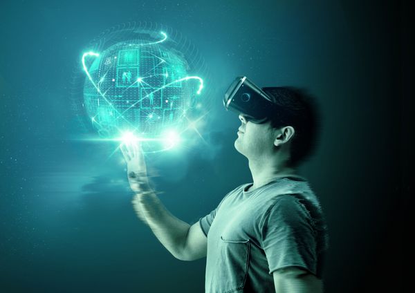 مرد جوانی با عینک و هدست واقعیت مجازی VR با تصویری از دنیای دیجیتال