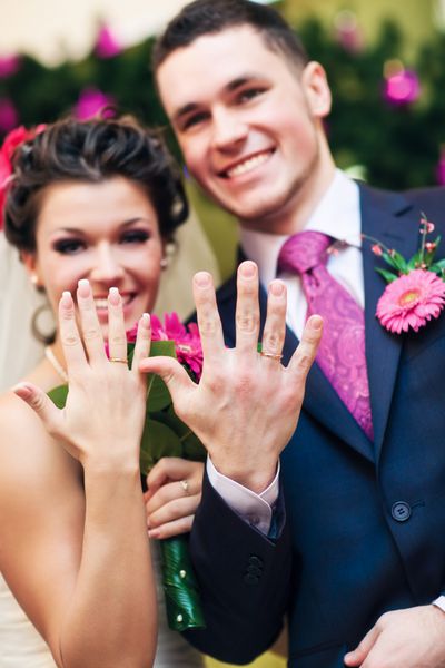 زوج جوان عروسی که حلقه های خود را نشان می دهند روی دست ها تمرکز کنید