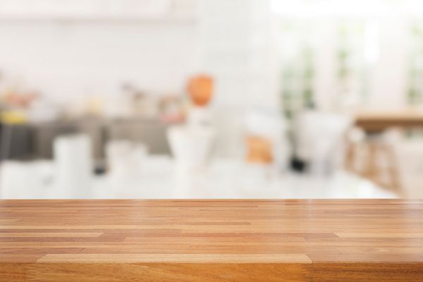 میز چوبی خالی و پس زمینه کافه آشپزخانه مدرن سفید رستورانت آماده برای مونتاژ محصول