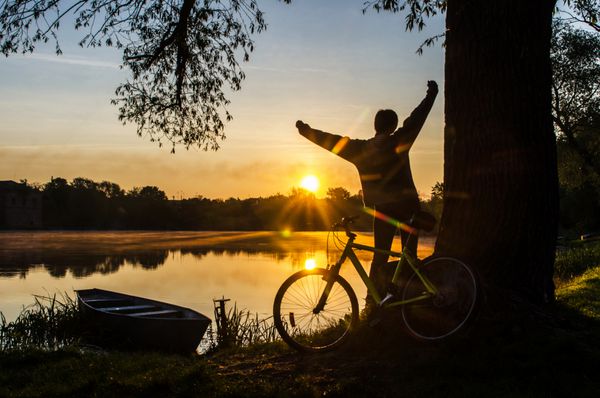 دختر با دوچرخه در صبح در رودخانه
