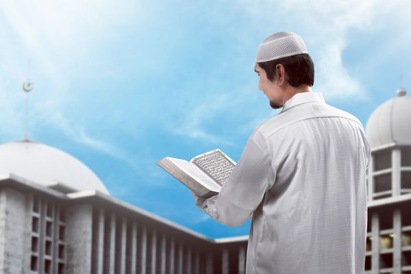 جوانان مسلمان آسیایی در حال خواندن قرآن