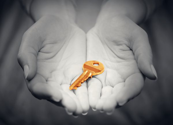 کلید طلایی در دست زن به نشانه هدیه دادن مفهوم موفقیت در راه حل های زنده تجاری املاک و غیره