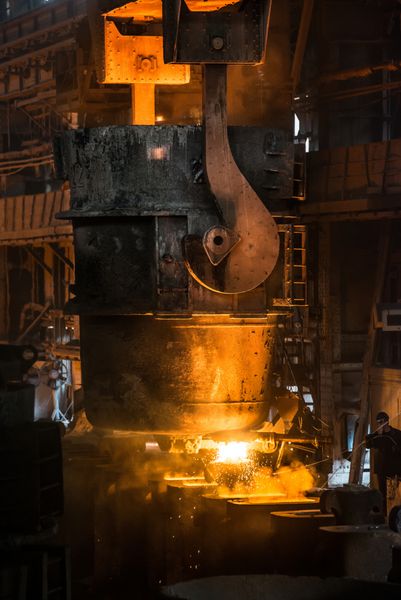فولادکار فلز مایع را از مخزن به داخل قالب می ریزد