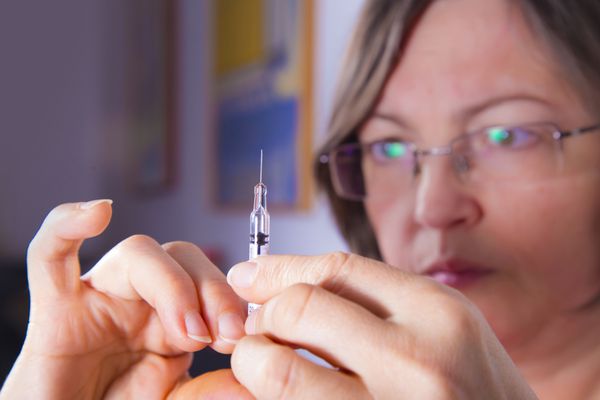 زن بالغ در حال آماده کردن سرنگ برای تزریق درمان داخل وریدی درمان دیابت انسولین