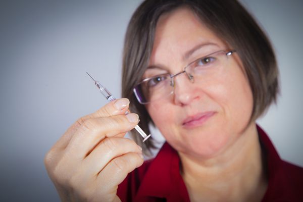 زن بالغ در حال آماده کردن سرنگ برای تزریق درمان داخل وریدی درمان دیابت انسولین