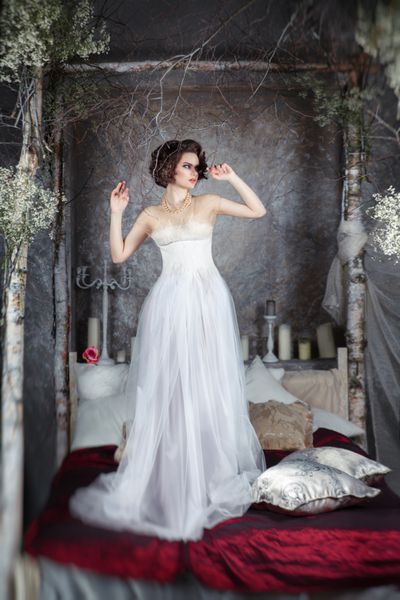 عروس جذاب با لباسی بلند در فضای داخلی مرموز