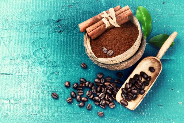 دانه های قهوه برشته شده با قهوه آسیاب شده و چوب دارچین