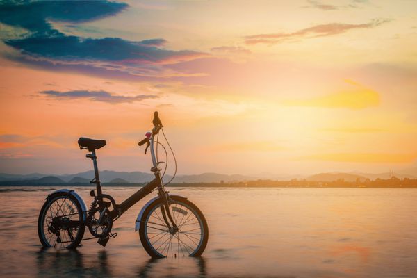 دوچرخه سیلوئت در ساحل در غروب آفتاب لحن قدیمی