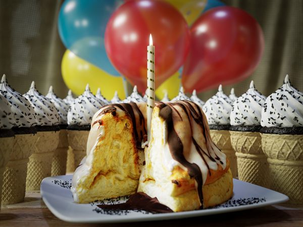 عکس مفهومی بسیاری از قیفی بستنی و کیک تولد روی میز چوبی قدیمی