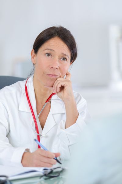 دکتر زن در حال گوش دادن به مطب بیمارش