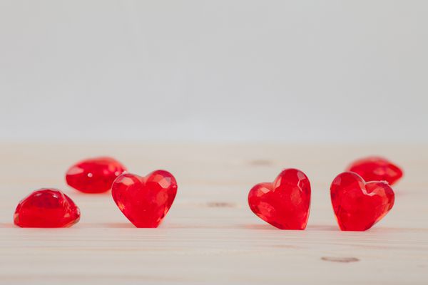 قلب قرمز پلاستیکی در زمینه چوبی