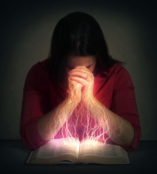 زن بر سر کتاب مقدس دعا می کند