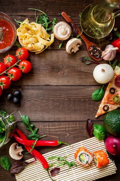 قاب ساخته شده از سبزیجات پیتزا رول سوشی پاستا و سس در زمینه چوبی تخت دراز کشید قاب غذا