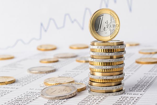 پشته یورو از سکه ها در برگه داده در مقابل نمودار سهام مفهوم مالی کسب و کار