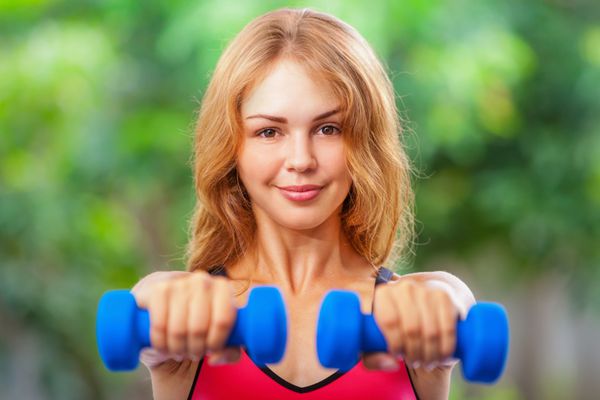 زن ورزشکار فعال در حال انجام تمرینات صبحگاهی با دمبل در خانه برنامه تمرینی برای گرفتن اندام ساحلی تابستانی سبک زندگی سالم تمرینات تناسب اندام برای حفظ تناسب اندام کاهش وزن و شکل دادن به اندام باریک عالی