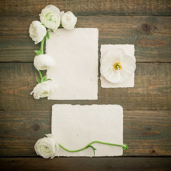 کارت های کاغذی پاکت نامه و گل های سفید در زمینه چوب تخت خوابیده نمای بالا پس زمینه قدیمی