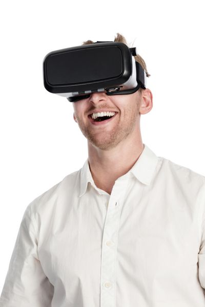 مردی با پیراهن سفید با عینک واقعیت مجازی در مقابل پس‌زمینه‌ای سفید با دهان باز ایستاده است