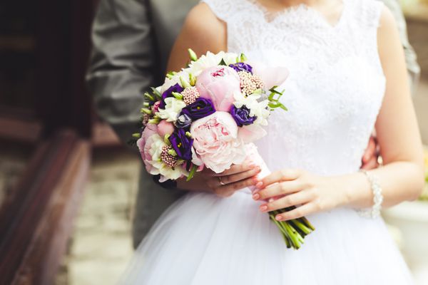 دست های تازه ازدواج کرده با دسته گل عروس از نمای نزدیک مفهوم ازدواج