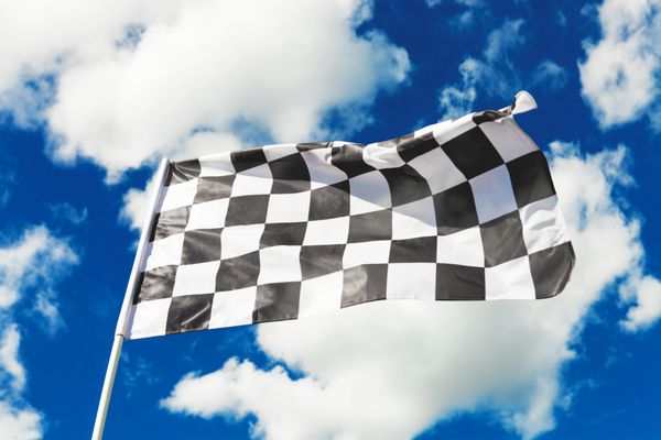 پرچم شطرنجی با آسمان آبی و ابرهای پشت آن در اهتزاز است تصویر فیلتر شده جلوه پرنعمت پردازش شده متقابل