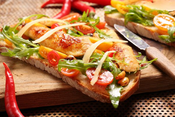 ساندویچ مرغ روی نان تازه با گوجه فرنگی و پنیر