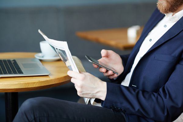 کارفرما با روزنامه و پیام های تلفن هوشمند در زمان استراحت