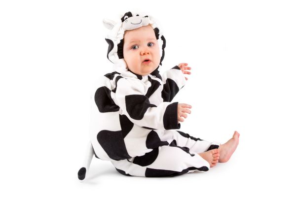 نوزادی با لباس فانتزی گاو در زمینه سفید