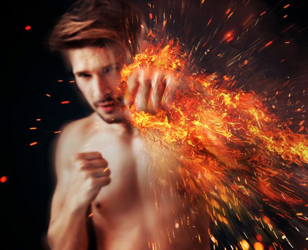 ورزشکار خوش تیپی که با شعله به دور مشت خود مشت می کند
