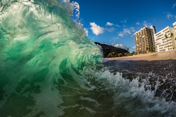 موج سبز بزرگی که در ساحل نزدیک هتل در ساحل سقوط می کند