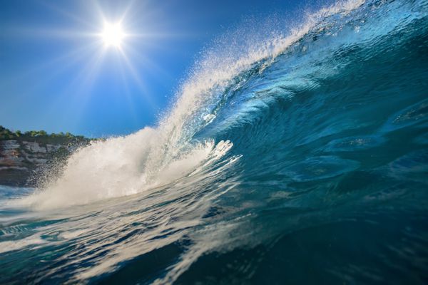 موج موج سواری تاج آبی اقیانوس آب دریا با خورشید بر فراز آسمان آبی در پس زمینه هیچ کس روی تصویر