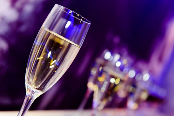 لیوان شامپاین مهمانی لوکس در چراغ‌های نئون کلوپ شبانه