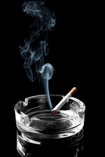 Closeup سیگار را در زیرسیگاری با بصورت حلقه در اوردن از دود