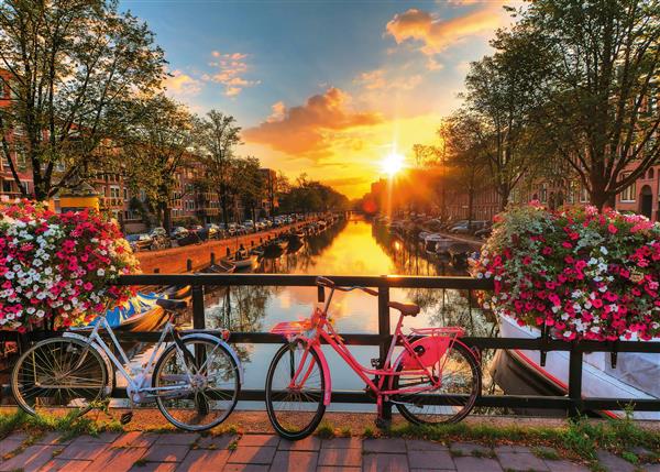 منظره رود و کانال راونسبورگر در آمستردام پل با دوچرخه های رنگی و غروب خورشید