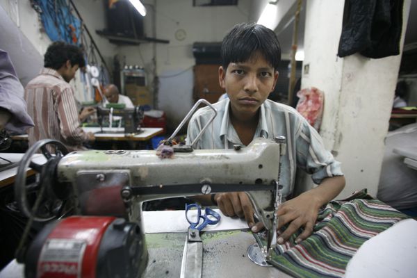 پسر جوان کار در کارخانه نساجی دهلی نو در هند